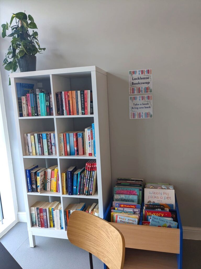 A large bookshelf with adult books and a floor level shelf with children's books.