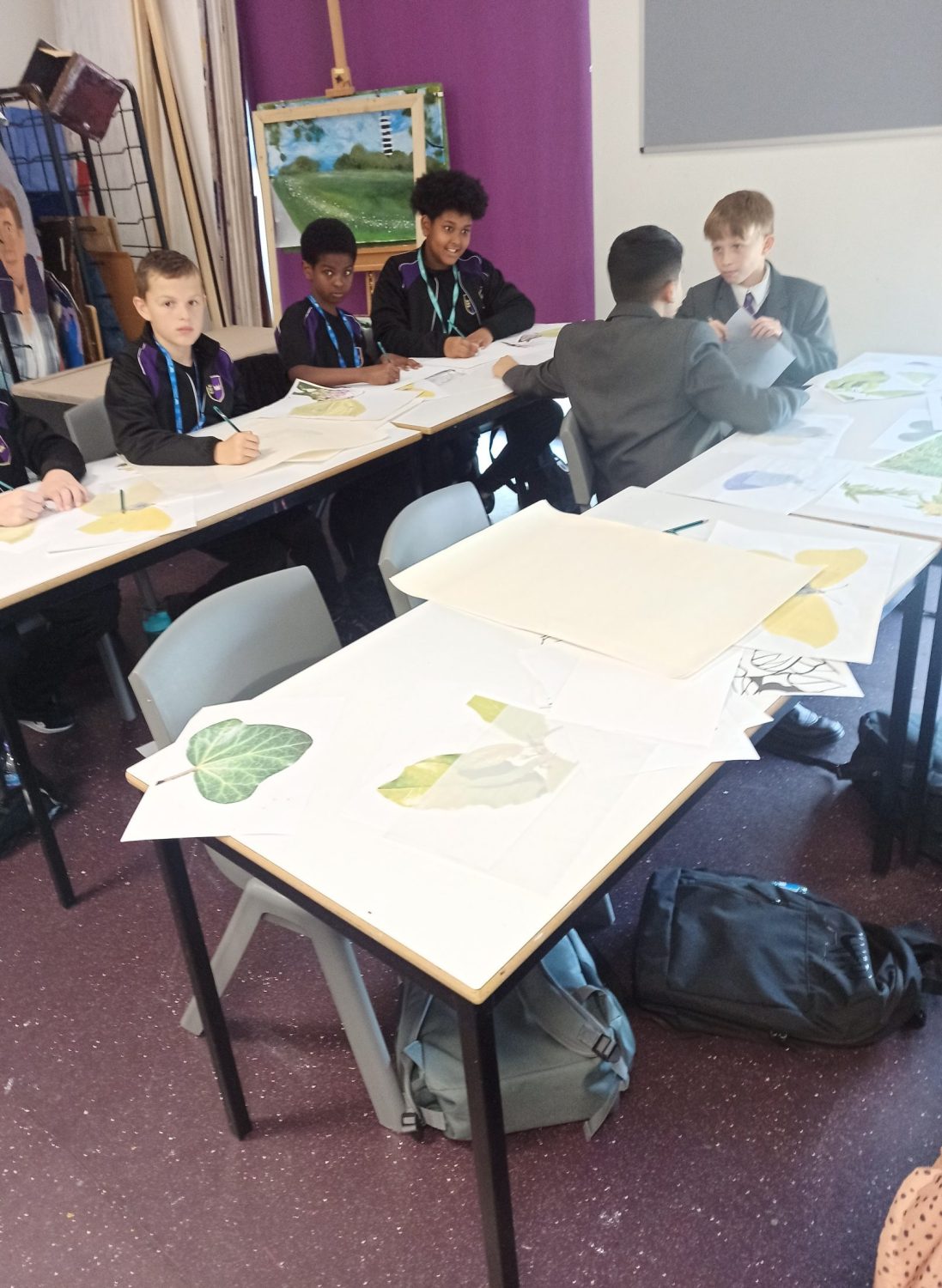trinity academy students chat with large pieces of paper with nature designs