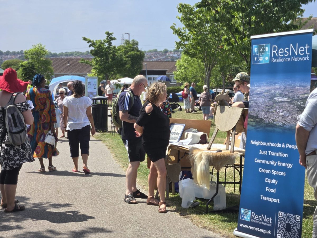 Stalls for 'resilience network' clean energy and street goat at a busy outdoor event