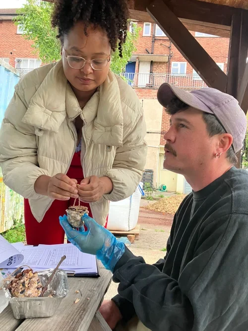A young Black woman and white man make bird feeders together