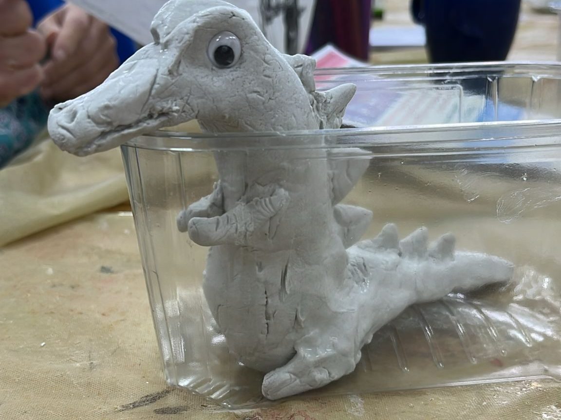 a dragon made of clay in a plastic tub