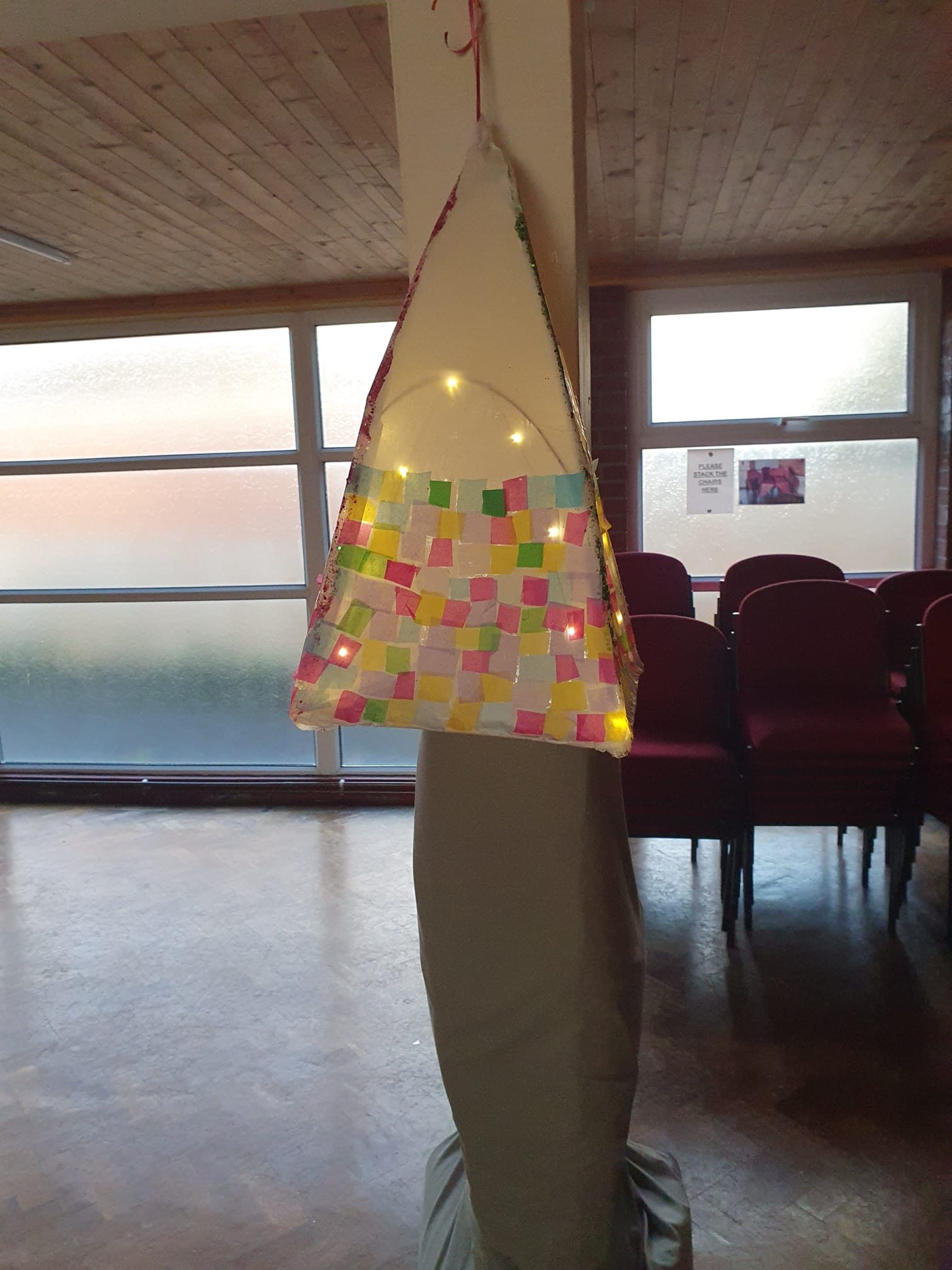 a paper lantern with pink and blue squares lit from the inside