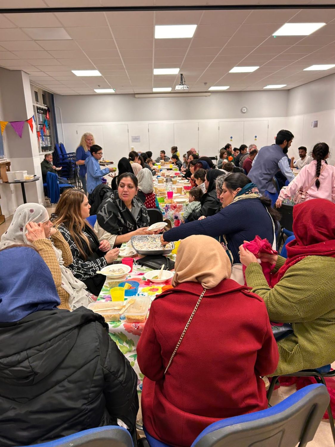 a busy hall with multiple tables of smiling people