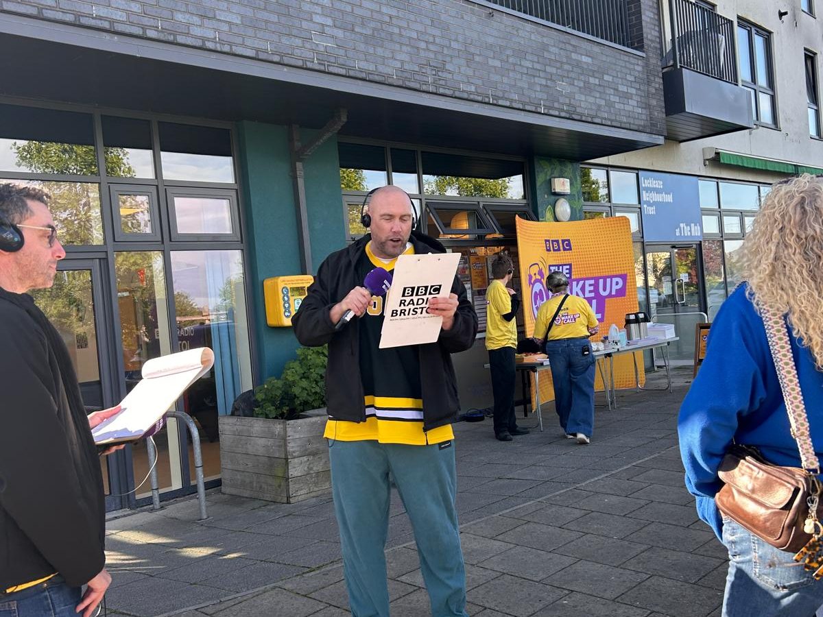 a tal white man with a mic and radio headphones outside the Hub