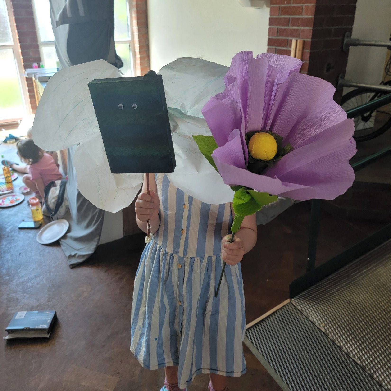 a child holding large tissue paper flowers in front of them