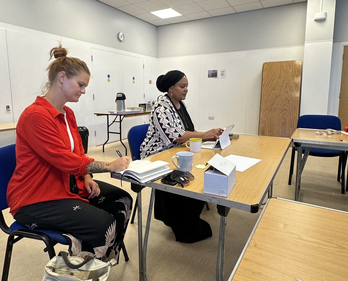 a white woman and a muslim woman sit at a table