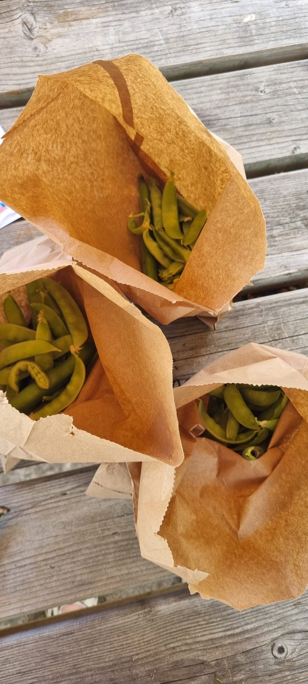 three paper bags of peas