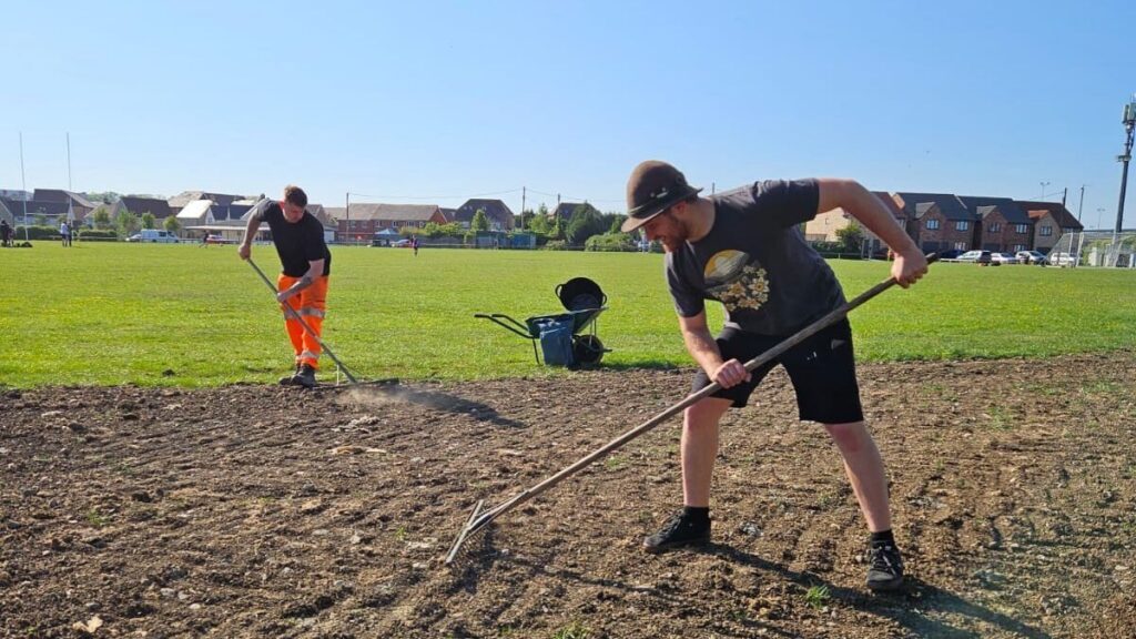 Eric raking seeds at Lockleaze Sports Centre with contractors from OCU